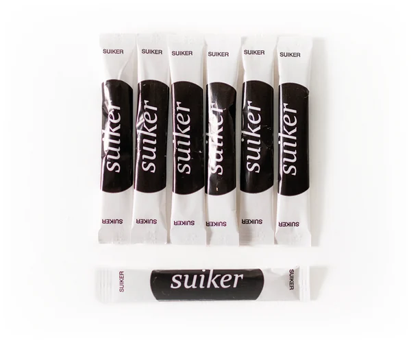 Rij witte suikersticks in een doseerbakje
