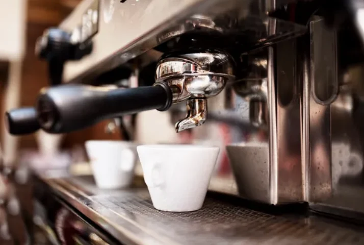Espressomachine op kantoor die twee kopjes koffie vult